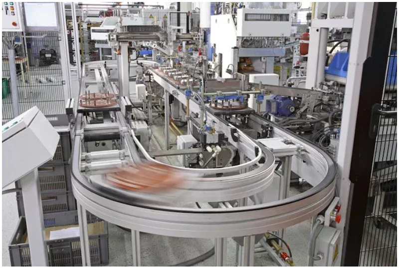 High-speed automated conveyor system in a modern factory with motion-blurred parts on a curved track
